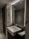 Spacious bathroom with modern fixtures and a large mirror in a hotel room.