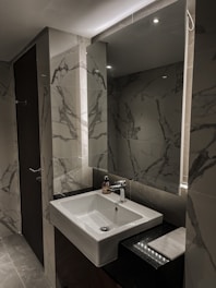 Modern bathroom in deluxe suite with clean white tiles.