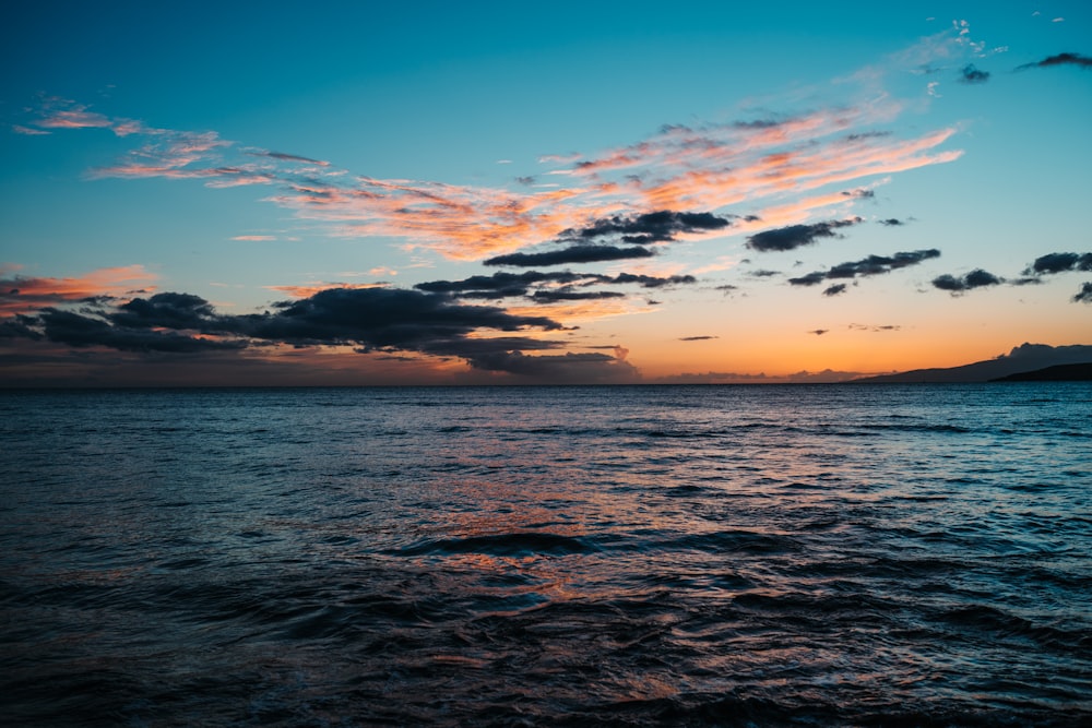 body of water under blue sky during sunset