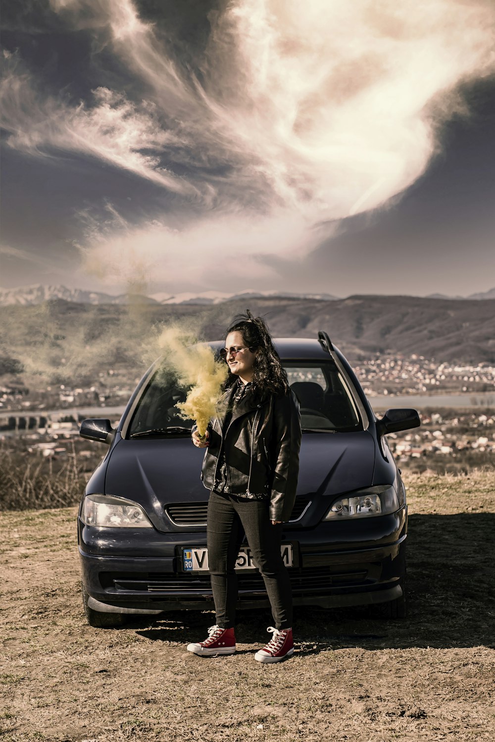woman in black jacket standing beside black car during daytime