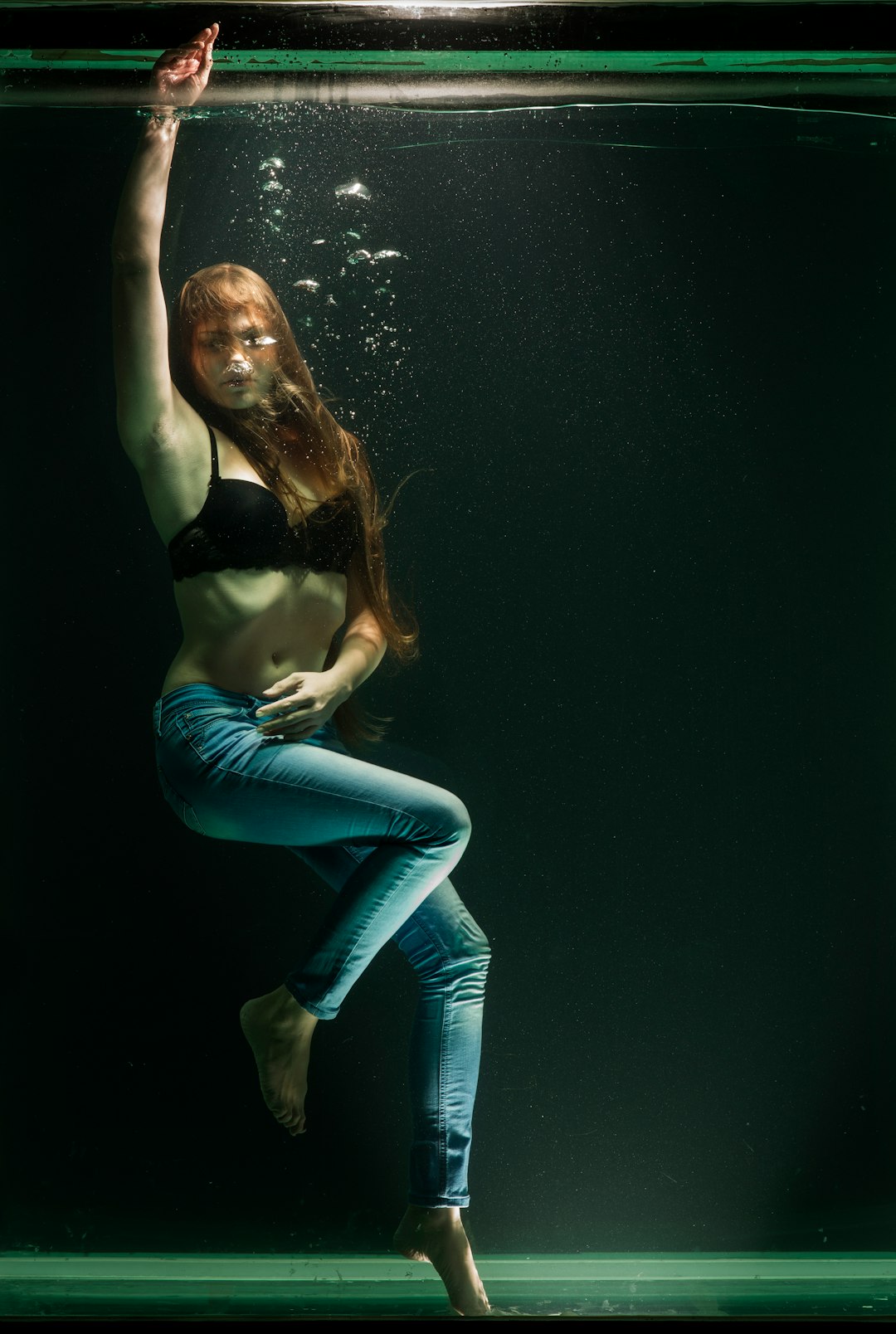 woman in black brassiere and blue denim jeans underwater