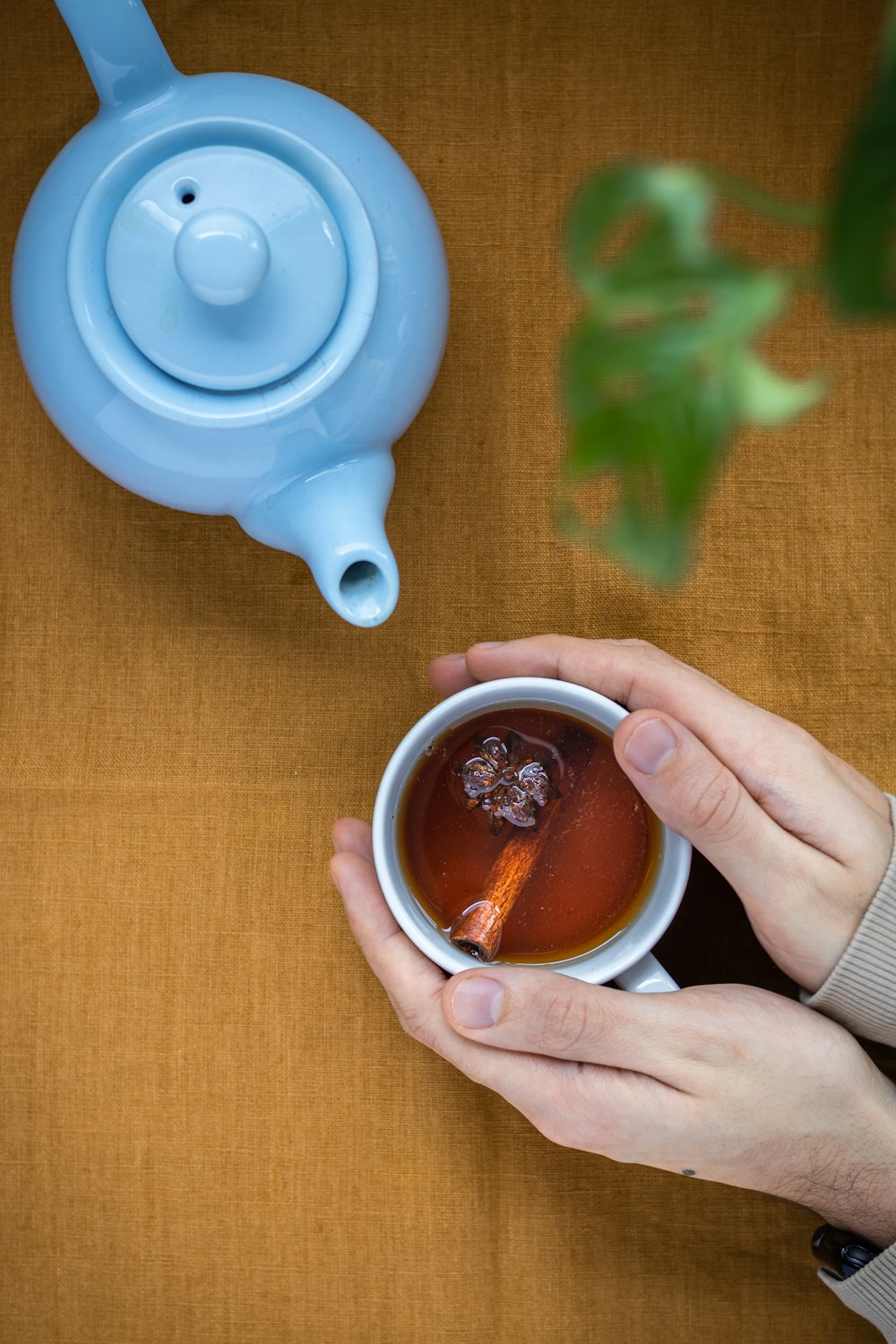 person holding white ceramic mug with brown liquid