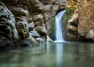 A peaceful waterfall surrounded by lush vegetation, showcasing Cajamarca's natural beauty.
