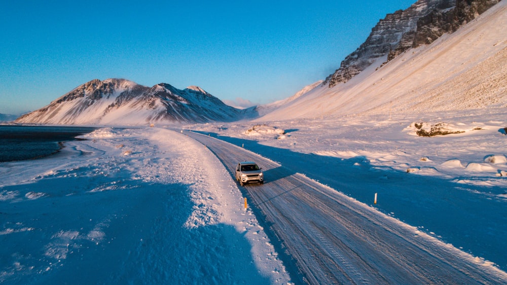 black car on road near snow covered mountain during daytime