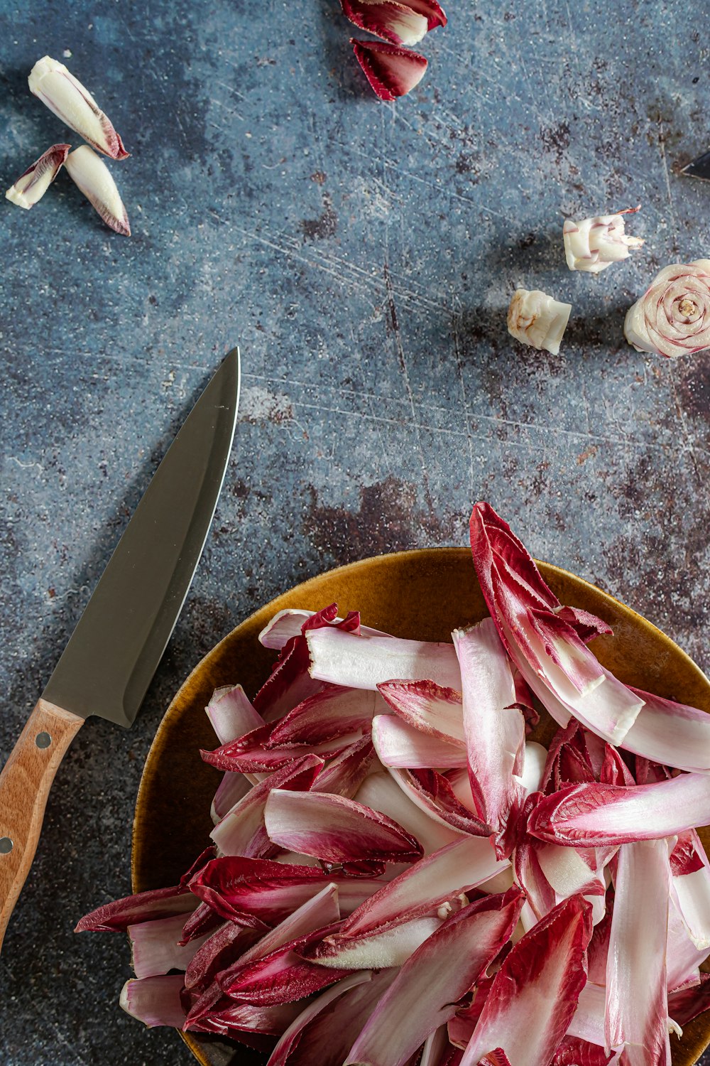 red and white sliced onions on brown wooden bowl