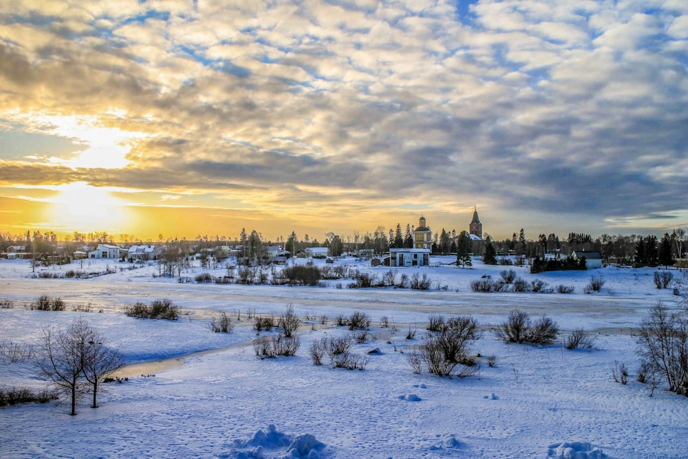 snow covered field under cloudy sky during daytime