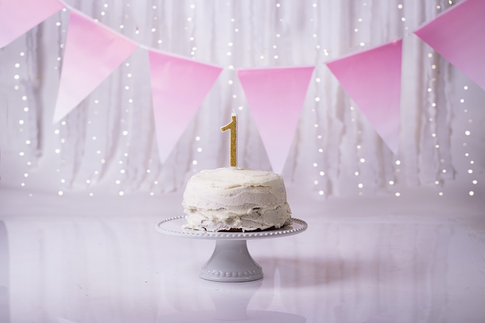 white and gold cake with pink umbrella