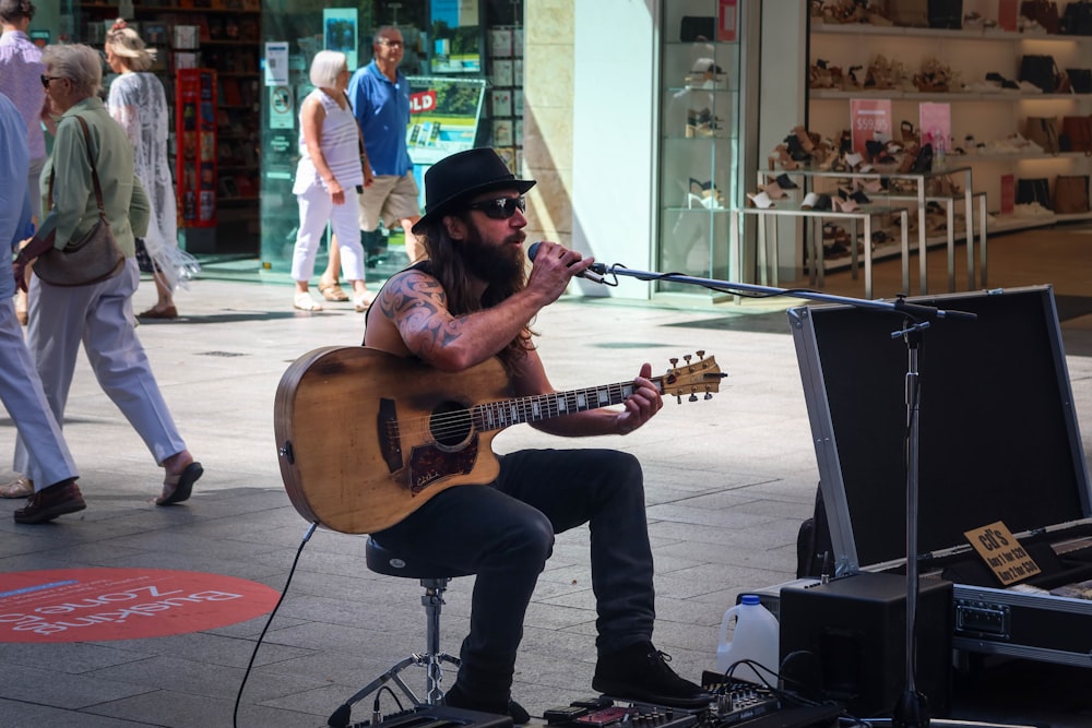 man in black hat playing guitar