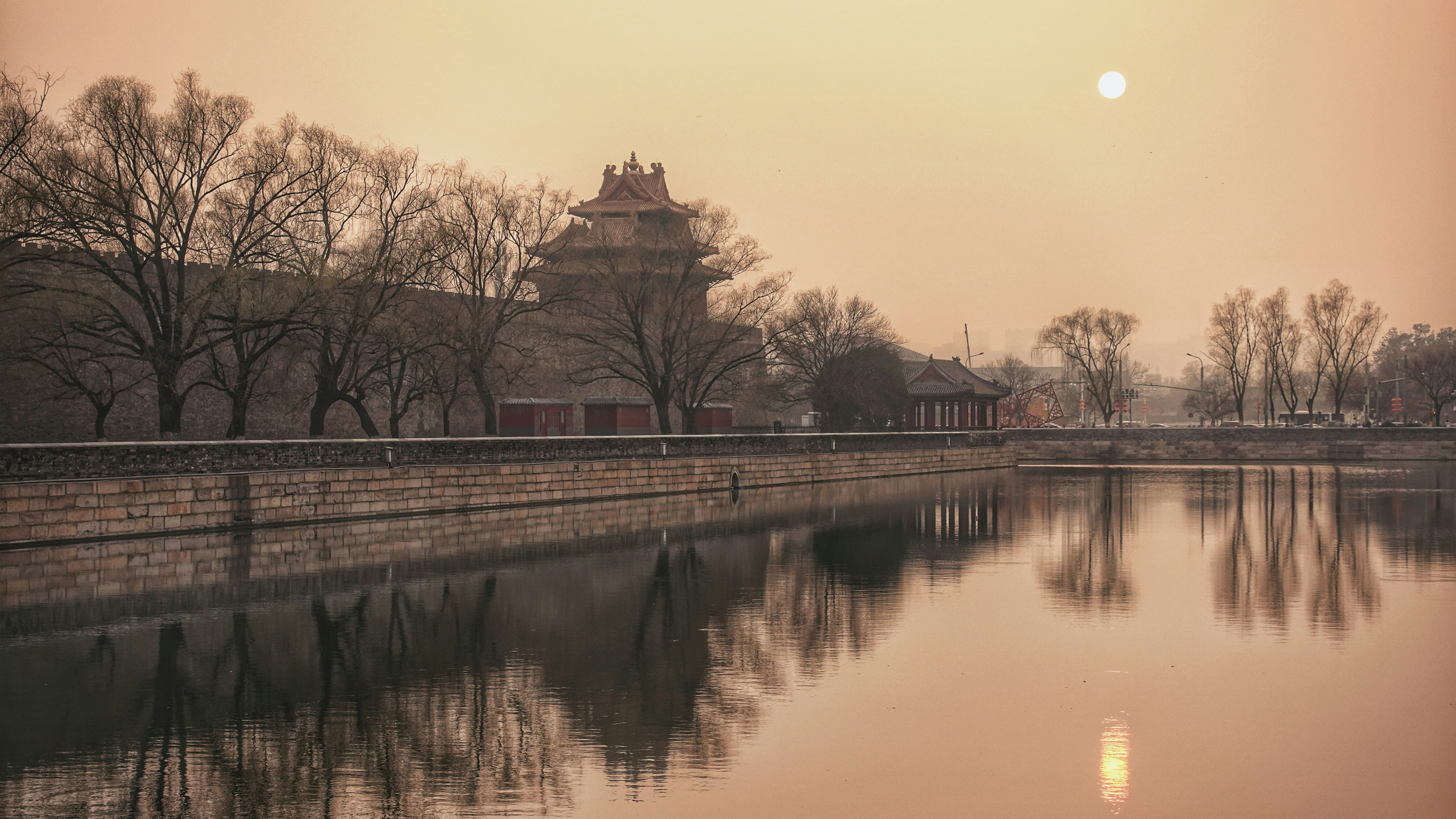 brown concrete building near body of water during sunset