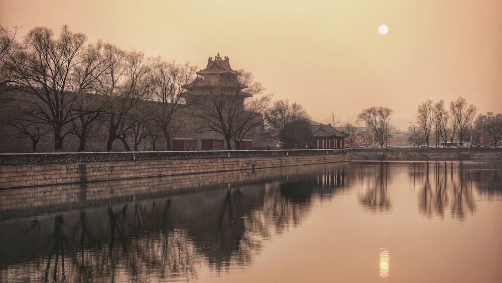 brown concrete building near body of water during sunset