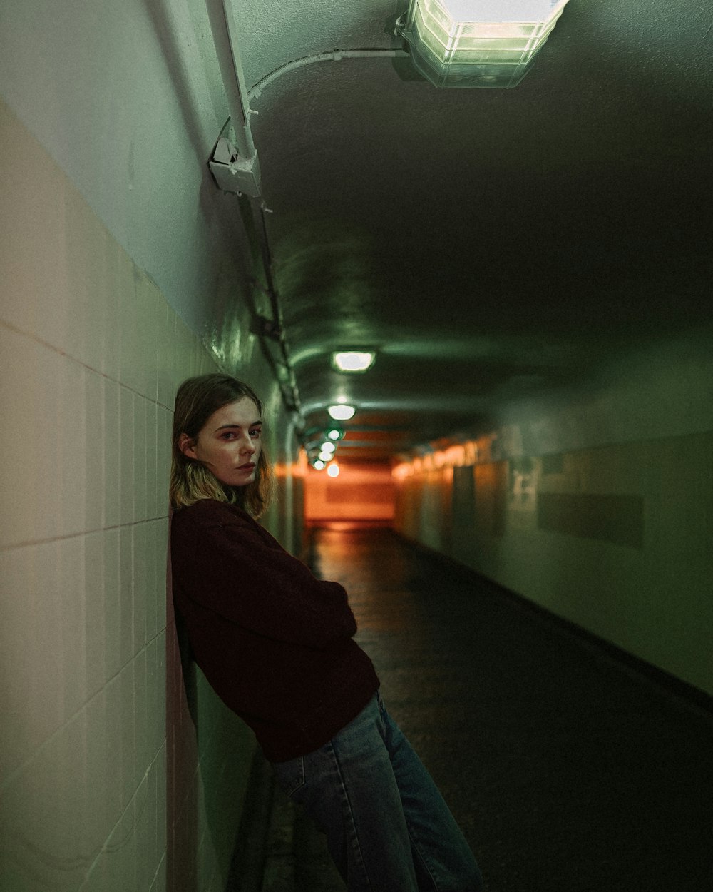 woman in black long sleeve shirt and blue denim jeans standing on hallway