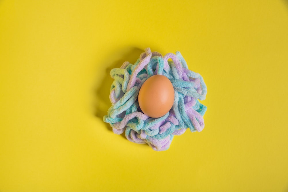 brown egg on green and purple flower