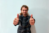 A smiling patient giving a thumbs up after a successful therapy session