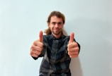 A smiling client giving a thumbs up in a clean room.