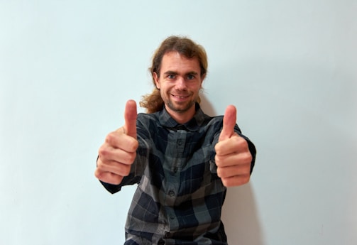 A smiling client giving a thumbs up in a clean room.