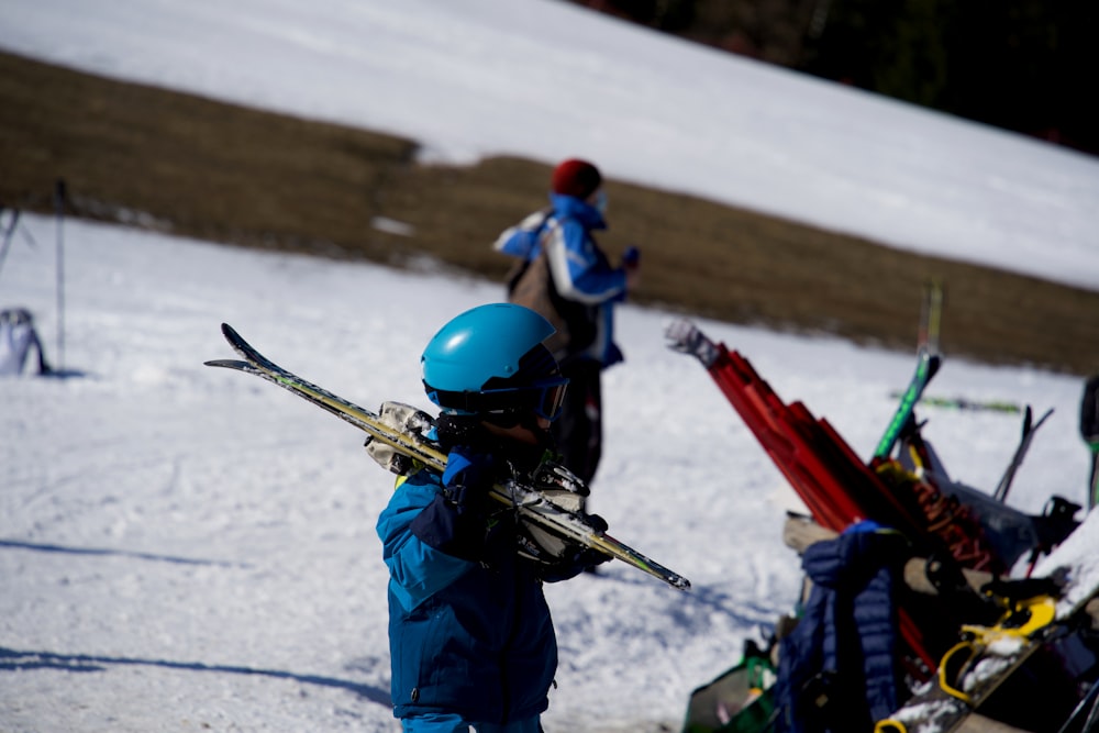 赤と黒のスノースキーボードを持つ青いジャケットとヘルメットの男性
