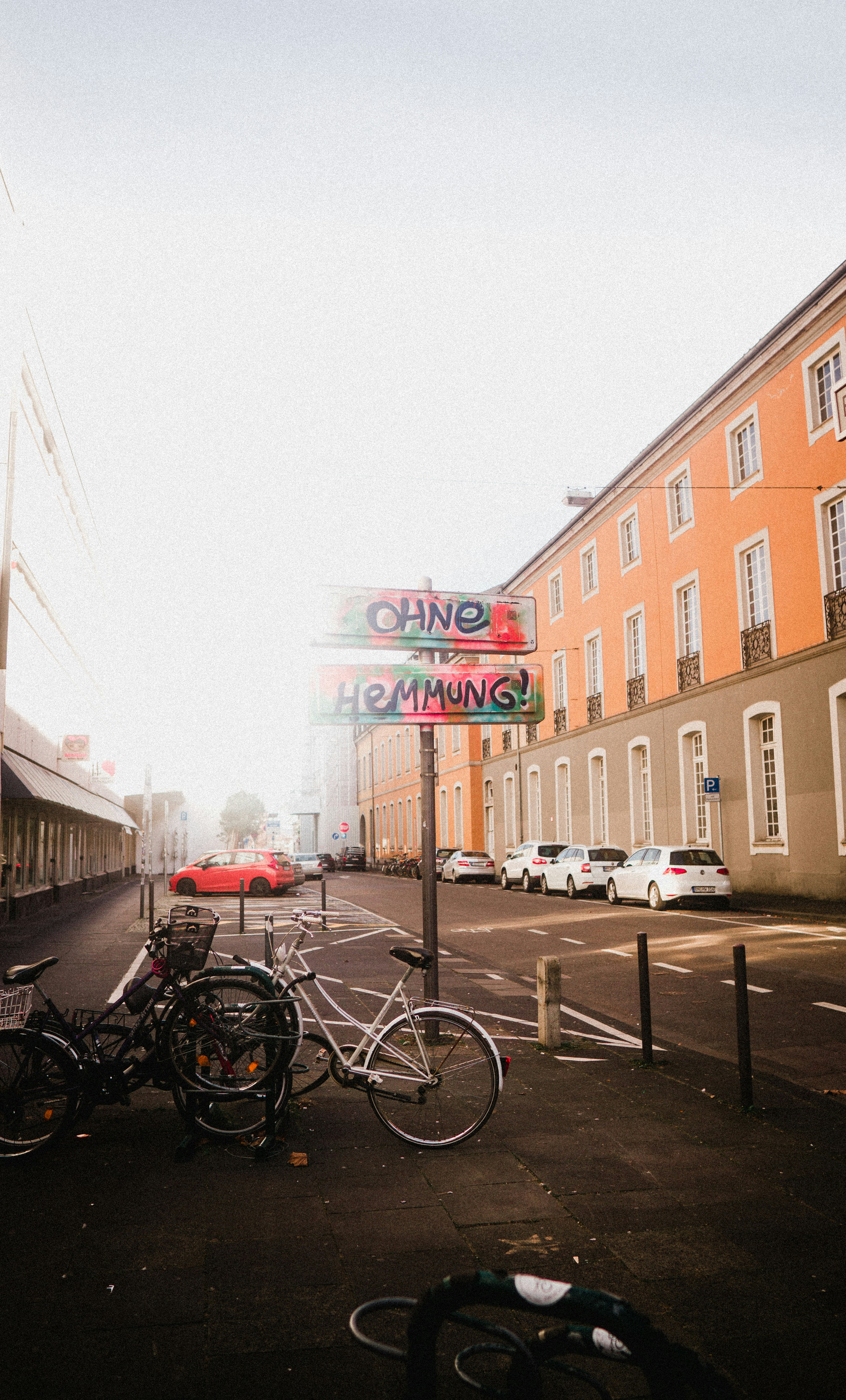 white car parked beside brown concrete building during daytime
