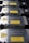 A row of metallic laser modules with visible warning labels and engraved text. The modules are aligned neatly, showcasing their industrial design. The labels contain laser hazard warnings and technical specifications.
