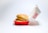 A sesame seed hamburger bun encases crispy fried chicken in a red and white fast food box, slightly open and tilted, with branding text visible on the lid. The box rests against a plain white background, emphasizing the simplicity and cleanliness of the presentation.