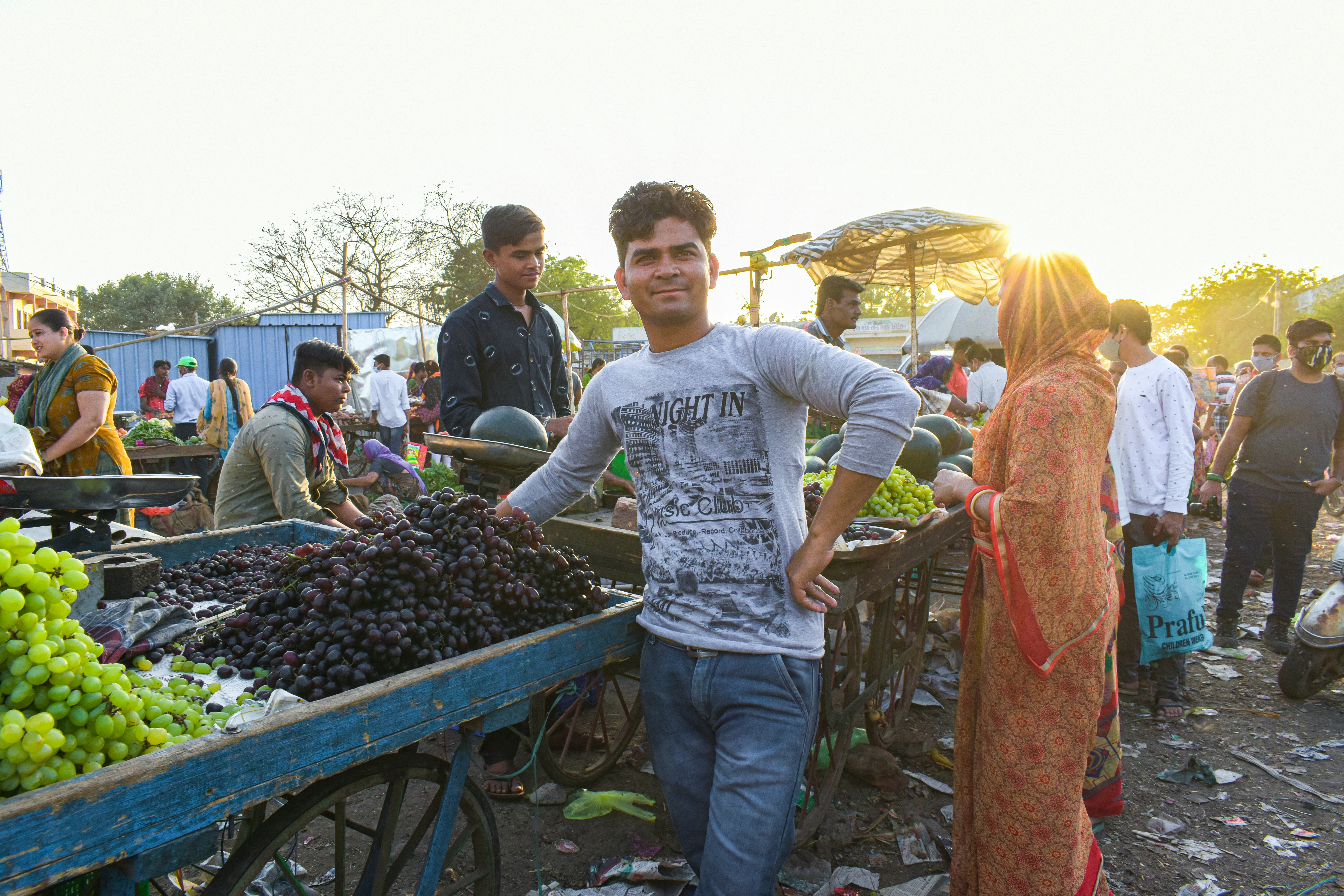man in white crew neck t-shirt standing beside woman in orange hijab