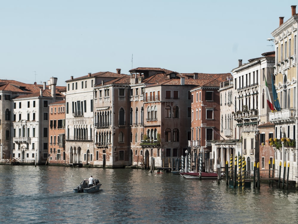 boat on water between buildings during daytime