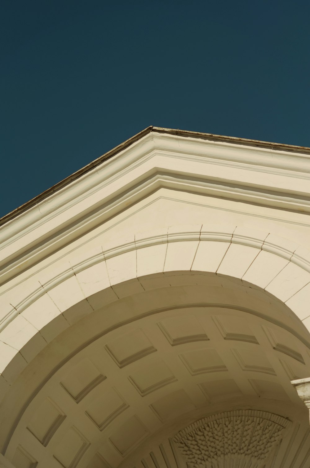 Bâtiment en béton blanc sous le ciel bleu pendant la journée