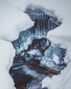 white snow on black and brown rock formation