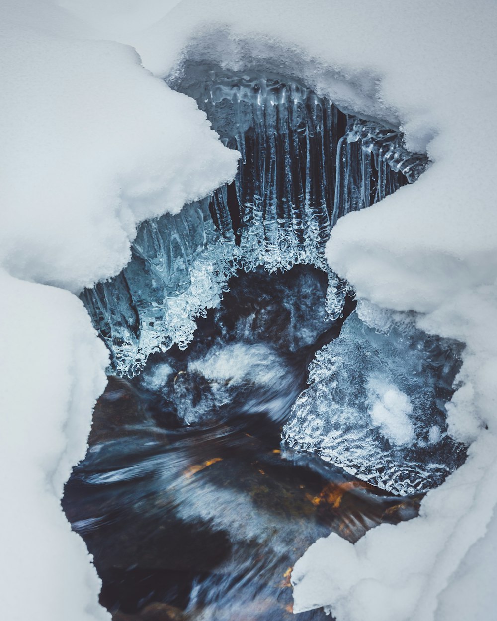 white snow on black and brown rock formation