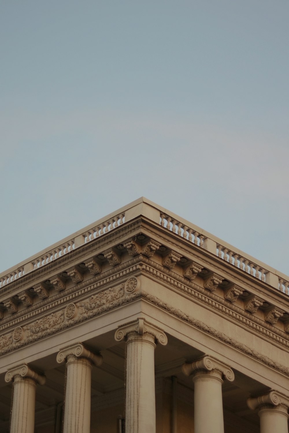 a building with columns and a clock on the top of it