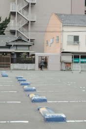 blue plastic trash bin on sidewalk