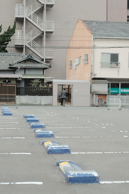 blue plastic trash bin on sidewalk