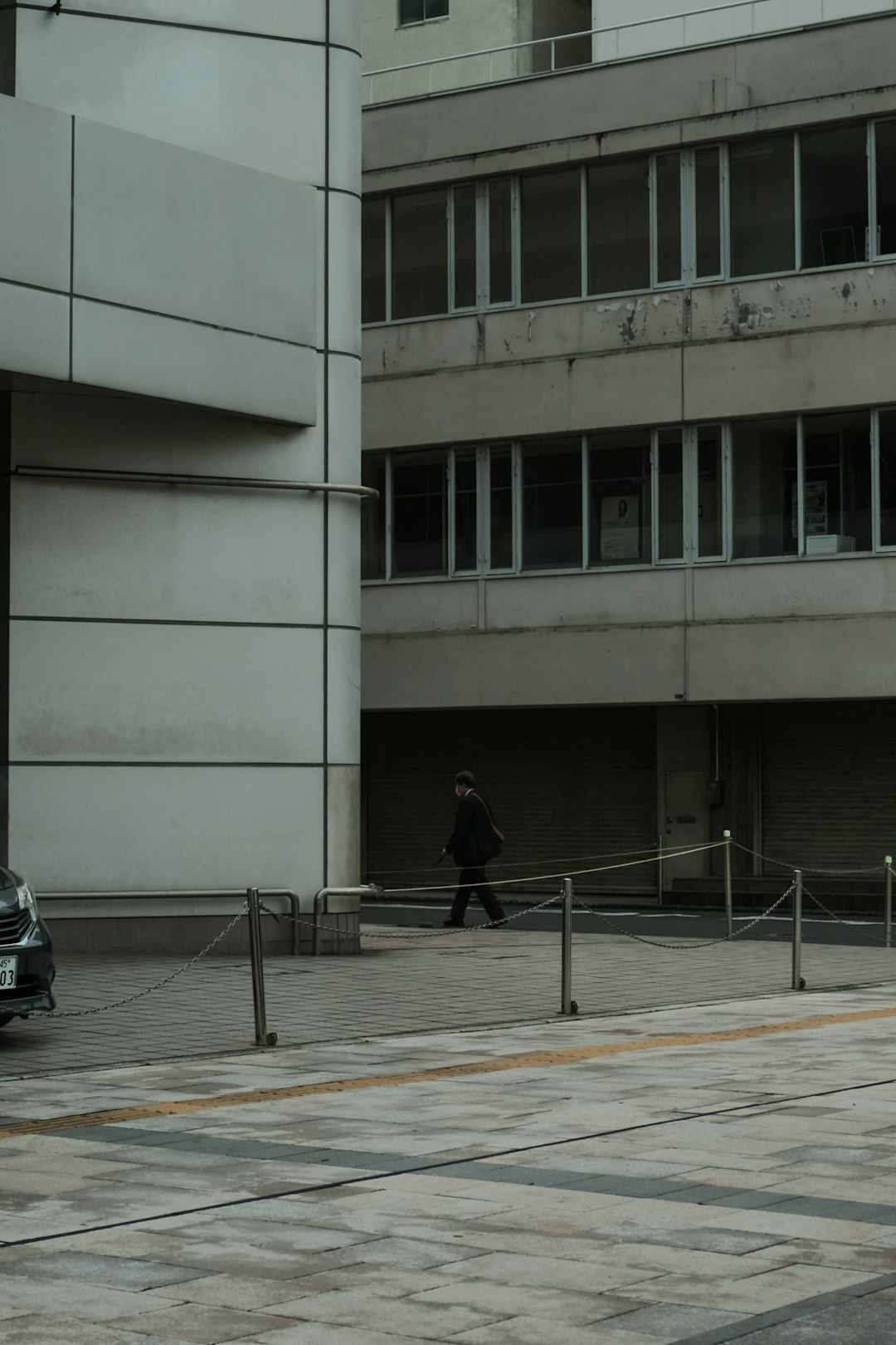 person in black jacket walking on sidewalk during daytime