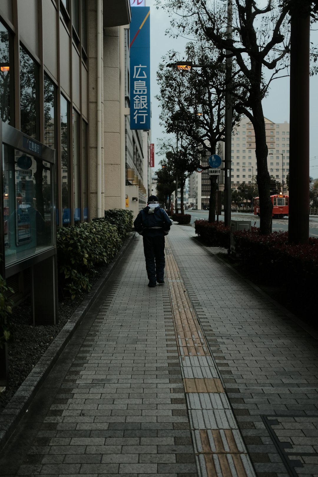 person in black jacket walking on sidewalk during daytime