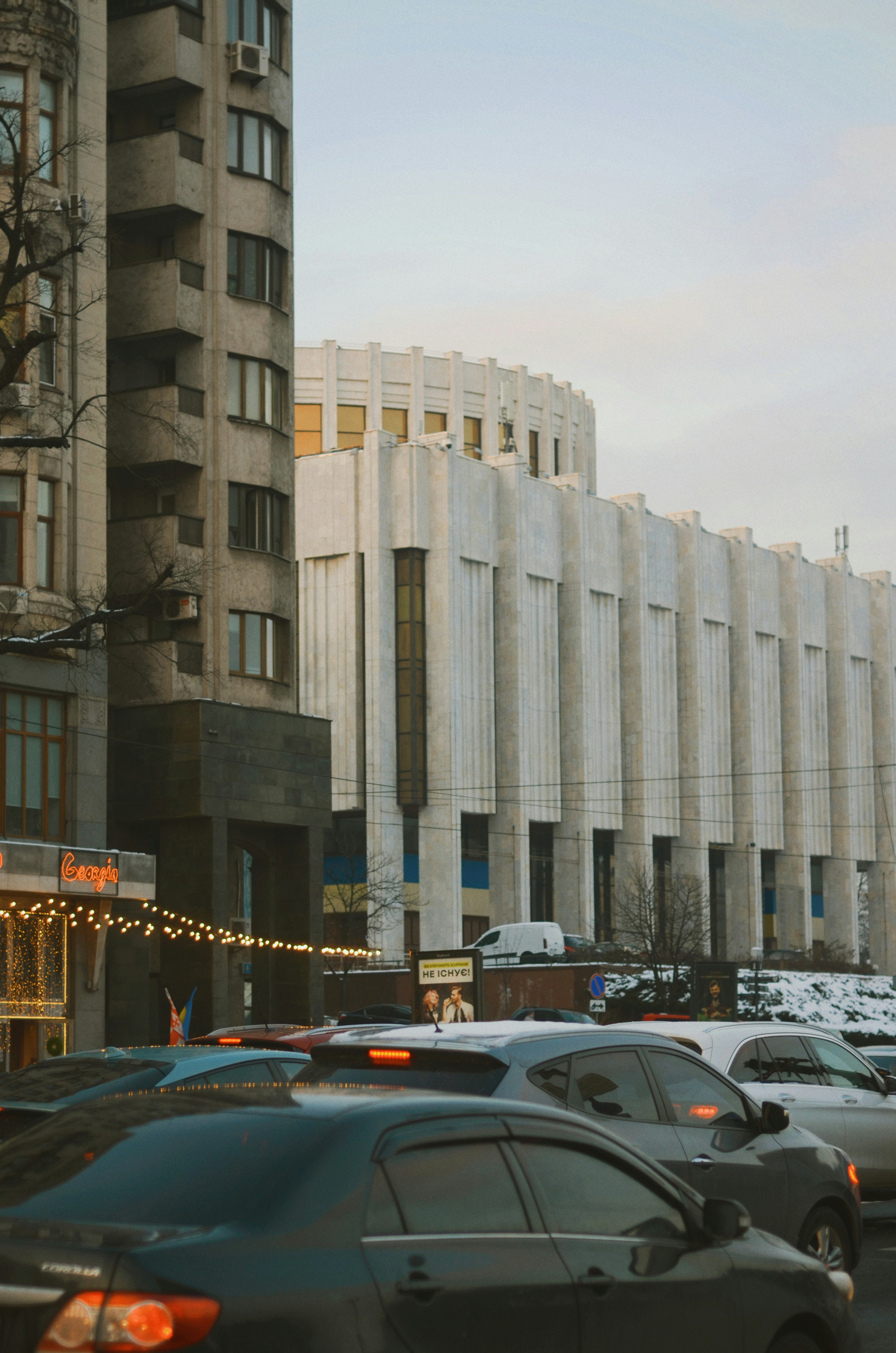 cars parked in front of white concrete building during daytime