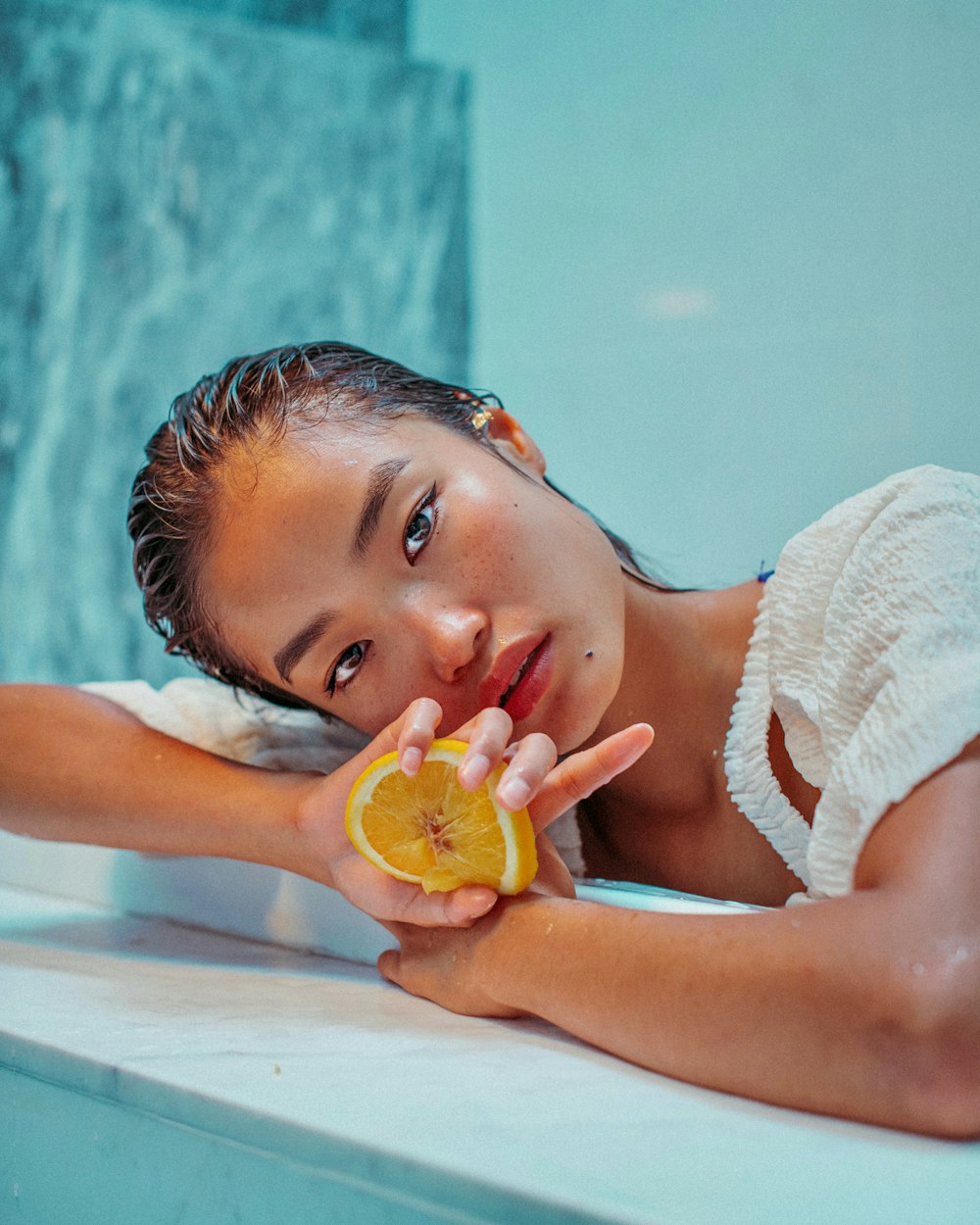 mujer en toalla de baño blanca con fruta amarilla
