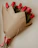 Close-up of a vibrant bouquet of roses and tulips wrapped in rustic paper.