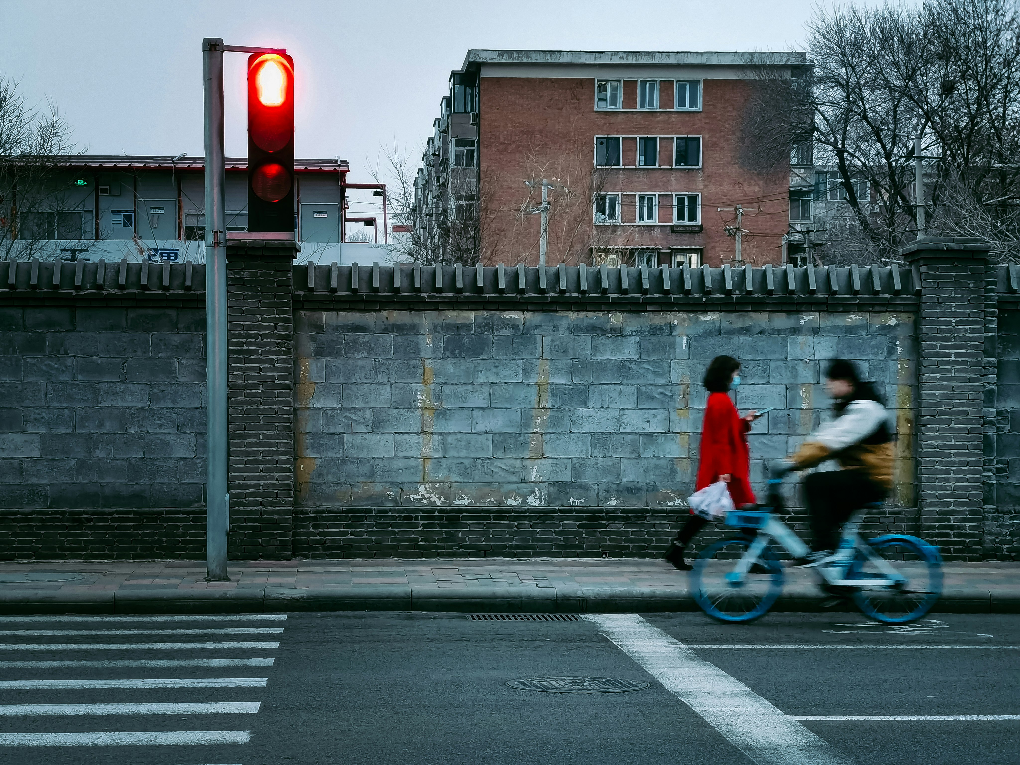 man in red jacket riding bicycle on road during daytime