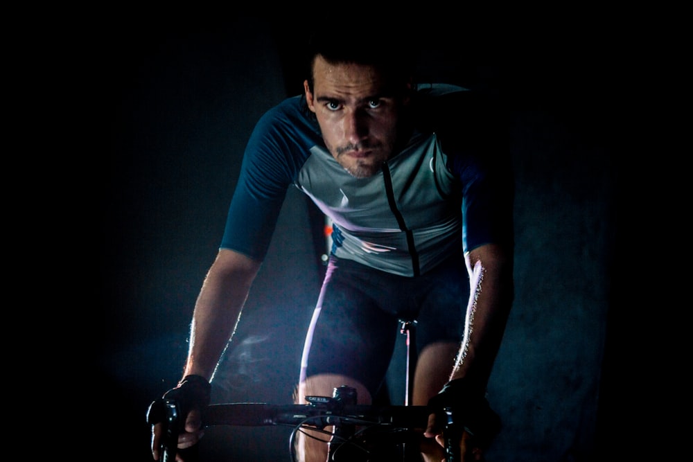man in blue crew neck t-shirt and black shorts riding bicycle
