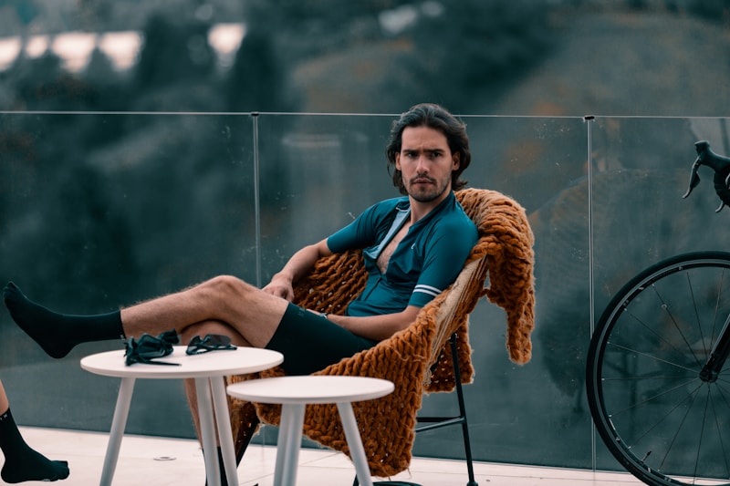 man in blue and brown jacket sitting on brown wicker chair