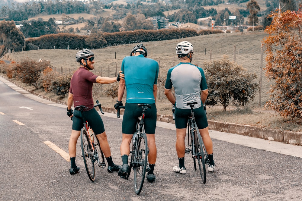 2 women in blue and black shirt riding bicycle on road during daytime