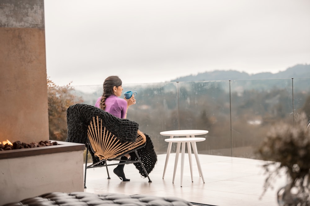 2 women sitting on chair near body of water during daytime