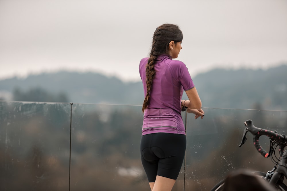 woman in pink shirt and black shorts running on road during daytime