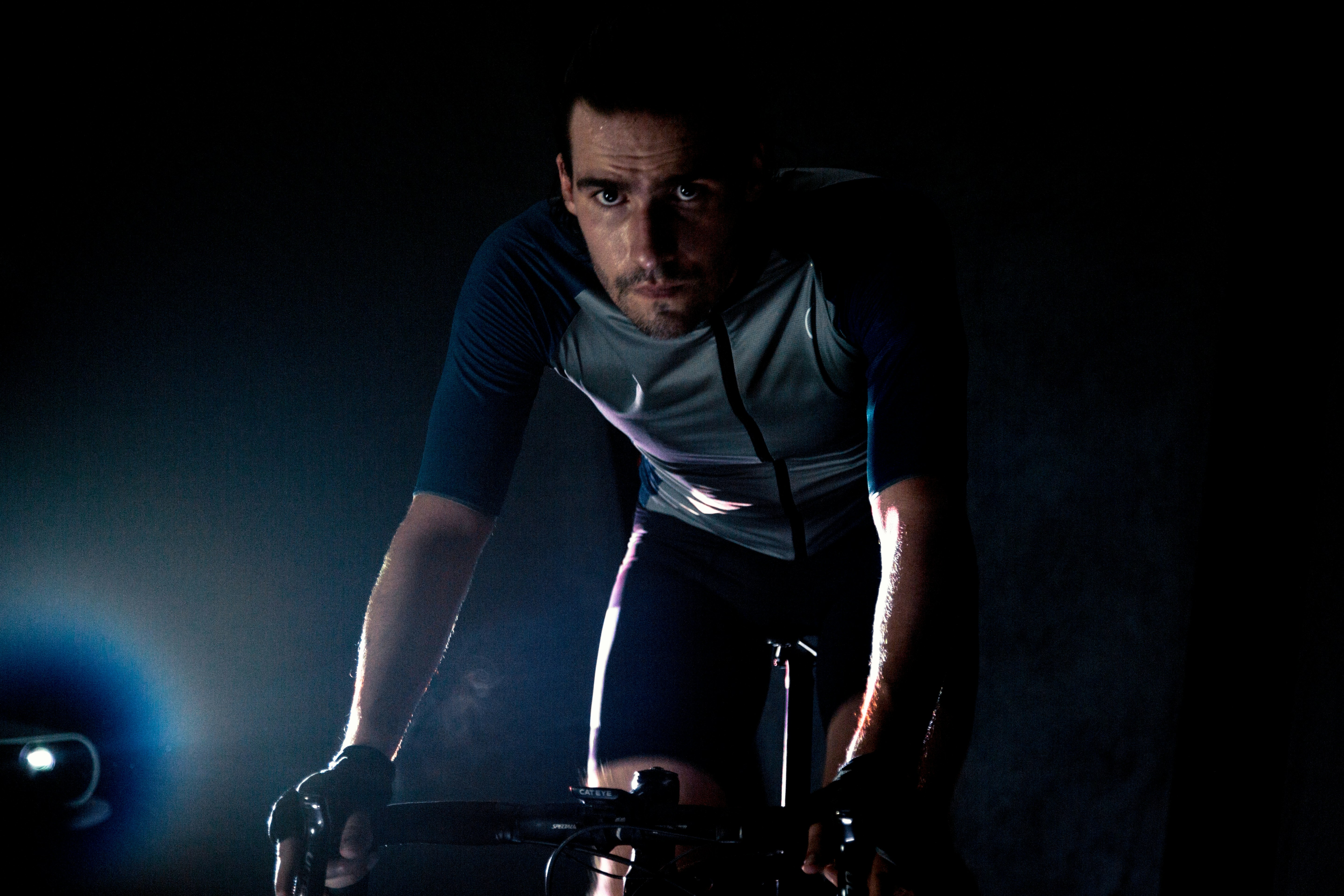 man in blue and black long sleeve shirt and black pants riding on bicycle