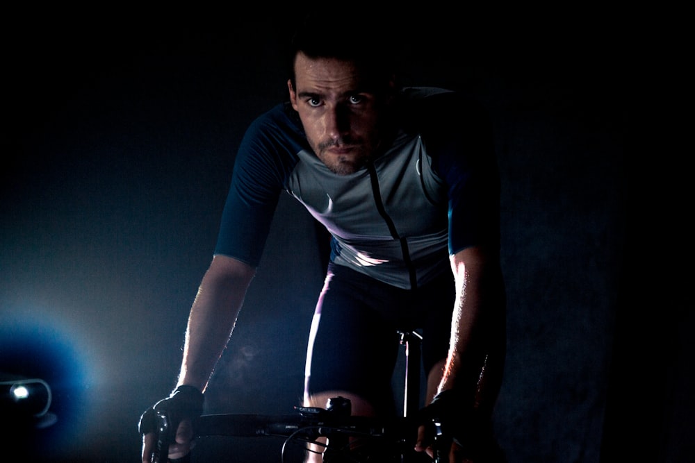 man in blue and black long sleeve shirt and black pants riding on bicycle
