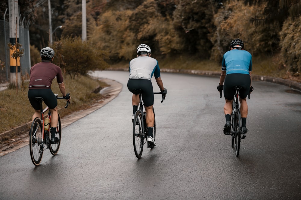 2 men riding on bicycle on road during daytime