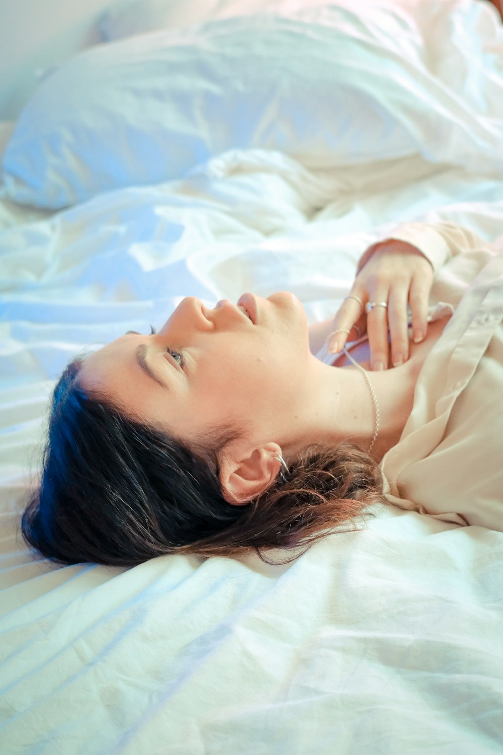 woman in white shirt lying on bed