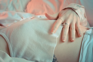 person holding her belly and wearing silver ring