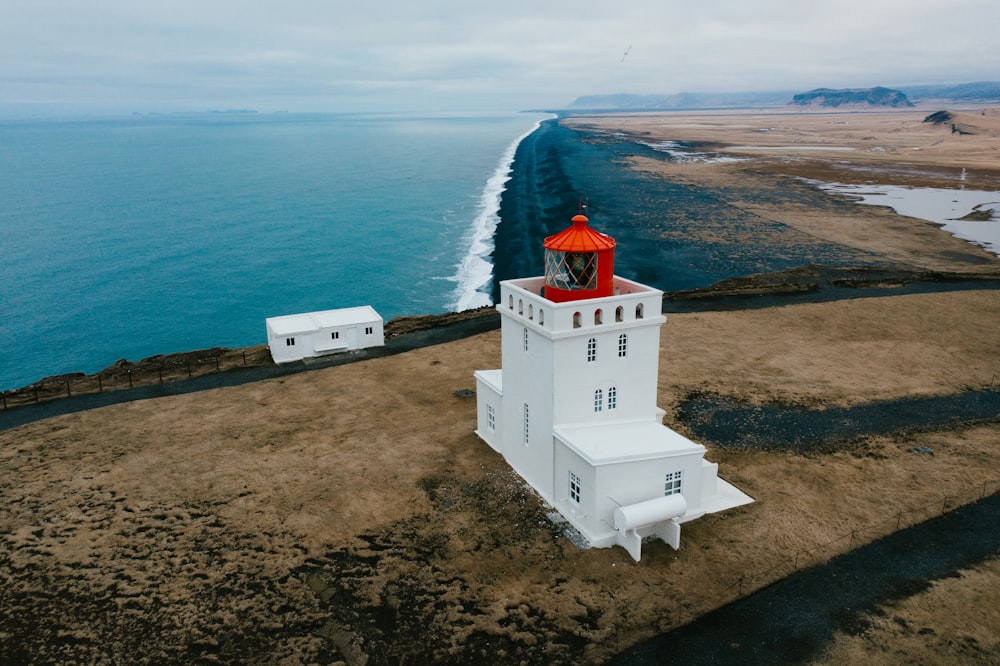 white and red concrete building near body of water during daytime