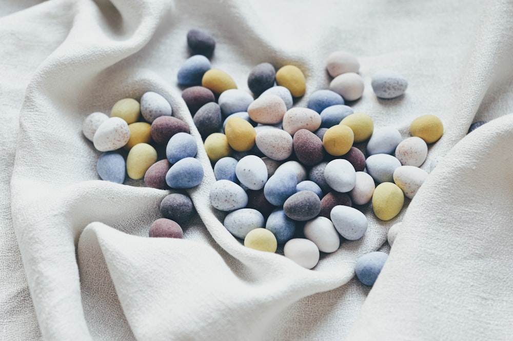 white blue yellow and green pebbles on white textile