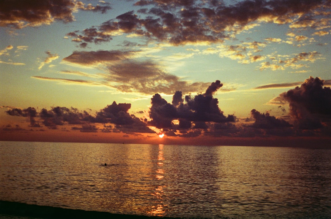 body of water under cloudy sky during sunset